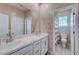 Bright bathroom featuring double sinks, sleek white cabinetry, and a shower-tub combo at 9990 Perth Ct, Las Vegas, NV 89141