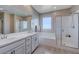 Bright bathroom featuring a double vanity, soaking tub, and glass-enclosed shower, creating a functional and luxurious space at 9990 Perth Ct, Las Vegas, NV 89141