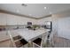 Bright kitchen features white cabinets, stainless steel appliances, and an island with granite countertops at 9990 Perth Ct, Las Vegas, NV 89141