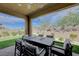 Covered patio with an outdoor dining set and a well-manicured artificial turf area, perfect for entertaining at 9990 Perth Ct, Las Vegas, NV 89141