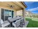 Outdoor covered patio with a dining set and a neatly landscaped artificial turf area for low-maintenance enjoyment at 9990 Perth Ct, Las Vegas, NV 89141