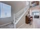 Bright entryway featuring a carpeted staircase with white railings, connecting the home's levels at 9990 Perth Ct, Las Vegas, NV 89141