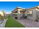 A sprawling backyard features a covered patio, lush artificial turf, and seamless indoor-outdoor living space at 12476 Heritage Bend Dr, Las Vegas, NV 89138