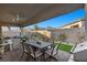 An outdoor patio showcases a dining table, comfortable seating, and views of the mountains beyond the backyard wall at 12476 Heritage Bend Dr, Las Vegas, NV 89138