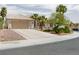 Charming single-story home with a beige exterior, well-manicured landscaping, and a two-car garage at 2212 Marble Gorge Dr, Las Vegas, NV 89117