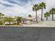 A view of a single-Gathering home with desert landscaping, palm trees, and a white wall at 2212 Marble Gorge Dr, Las Vegas, NV 89117