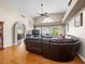 Spacious living room featuring hardwood floors, a ceiling fan, large windows, and an arched entry at 2212 Marble Gorge Dr, Las Vegas, NV 89117