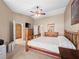 Spacious main bedroom featuring a ceiling fan, walk-in closet, television, and wood furniture at 2212 Marble Gorge Dr, Las Vegas, NV 89117