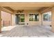 Back patio with large pavers, covered area with fan, surrounded by artificial grass and landscaping at 3528 Tack St, Las Vegas, NV 89122