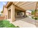 Back patio covered by a pergola, featuring pavers, artificial grass, landscaping, and a hot tub at 3528 Tack St, Las Vegas, NV 89122