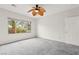 Spacious bedroom with a large window, white walls, and neutral carpet at 3528 Tack St, Las Vegas, NV 89122