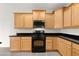 Well-lit kitchen featuring black appliances, light cabinets, and stone countertops at 3528 Tack St, Las Vegas, NV 89122