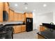 Bright kitchen with black appliances, stone countertops, and natural wood cabinets at 3528 Tack St, Las Vegas, NV 89122