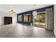 Bright living room featuring sliding glass doors, a modern light fixture, and blue accent wall at 3528 Tack St, Las Vegas, NV 89122