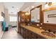 Bathroom with dual sinks, decorative mirrors, glass shower, and ample wood cabinet space at 5492 Royal Vista Ln, Las Vegas, NV 89149