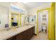 Bright bathroom featuring a double sink vanity with wooden cabinets, a separate toilet room, and a shower at 5492 Royal Vista Ln, Las Vegas, NV 89149
