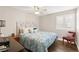 This bedroom boasts a cozy queen bed, a stylish accent chair, a ceiling fan, and a bright window with shutter blinds at 5492 Royal Vista Ln, Las Vegas, NV 89149
