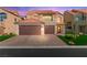 Attractive two-story home with a well-maintained lawn, paver driveway, and a two-car garage at 5492 Royal Vista Ln, Las Vegas, NV 89149