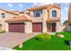 Lovely exterior view of two-story home with beautiful brick driveway and lush green landscaping at 5492 Royal Vista Ln, Las Vegas, NV 89149