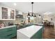 A kitchen featuring green cabinets, white countertops, modern appliances, tile backsplash and wood flooring at 5492 Royal Vista Ln, Las Vegas, NV 89149