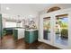 The kitchen boasts a center island, stainless steel appliances, green cabinets, and patio access at 5492 Royal Vista Ln, Las Vegas, NV 89149