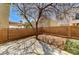 A private backyard featuring a concrete patio, brick perimeter, mature tree, and artificial grass at 6267 Dollar Bill Ct, Las Vegas, NV 89141