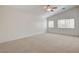 Large bedroom featuring neutral carpet, a ceiling fan, and abundant natural light through two windows at 6267 Dollar Bill Ct, Las Vegas, NV 89141
