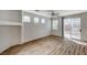 Spacious living room with wood laminate flooring and natural light from multiple windows at 6267 Dollar Bill Ct, Las Vegas, NV 89141