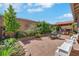 Spacious backyard featuring a paved patio, lush landscaping, and a covered outdoor dining area at 703 Shiva St, Las Vegas, NV 89178