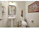 Charming powder room with a pedestal sink, decorative mirror, and elegant fixtures at 703 Shiva St, Las Vegas, NV 89178