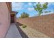 Home exterior featuring a gated side entrance and brick perimeter wall for added privacy at 703 Shiva St, Las Vegas, NV 89178