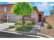 Inviting single-story home with mature tree, front yard landscaping, and welcoming entryway at 703 Shiva St, Las Vegas, NV 89178