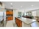 Spacious kitchen offers stainless steel appliances, an island with a sink, and warm-toned wood cabinets and drawers at 703 Shiva St, Las Vegas, NV 89178