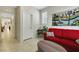 Inviting living room featuring neutral tones, a red sofa, and modern tile flooring at 703 Shiva St, Las Vegas, NV 89178