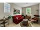 Cozy living room featuring a red sofa, decorative rug, and plenty of natural light at 703 Shiva St, Las Vegas, NV 89178