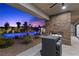 Backyard with pool and spa view from under the patio with stone fireplace and seating at 7477 Triple Knot Ct, Las Vegas, NV 89113