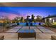 A luxurious backyard features a sparkling pool and lounge area under a vibrant evening sky at 7477 Triple Knot Ct, Las Vegas, NV 89113