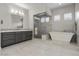 A modern bathroom features a double vanity, a walk-in shower, and a soaking tub at 7477 Triple Knot Ct, Las Vegas, NV 89113