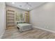 Simple bedroom with light wood floors, a minimalist bed frame, and natural light from the window at 7477 Triple Knot Ct, Las Vegas, NV 89113