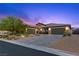 Beautiful home exterior featuring a three car garage, desert landscaping, and stone accents at 7477 Triple Knot Ct, Las Vegas, NV 89113