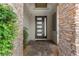A modern front entrance features a sleek door with stone accents and manicured landscaping at 7477 Triple Knot Ct, Las Vegas, NV 89113