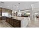 Open kitchen with large island, stainless steel appliances, stone countertops, and seamless flow into the dining area at 7477 Triple Knot Ct, Las Vegas, NV 89113