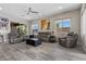 Spacious living room featuring comfortable leather seating, recessed lights, ceiling fan, and large windows for natural light at 7477 Triple Knot Ct, Las Vegas, NV 89113