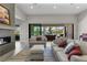 Inviting living room with a fireplace, comfortable seating, and scenic backyard views through sliding glass doors at 7477 Triple Knot Ct, Las Vegas, NV 89113
