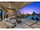 The outdoor patio features a stone fireplace, comfortable seating, and a view of the pool at 7477 Triple Knot Ct, Las Vegas, NV 89113