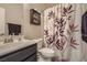 Cozy bathroom with decorative shower curtain, modern fixtures, and ample storage at 7788 Ebro Valley Ct, Las Vegas, NV 89113