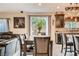 Stylish dining area with a wooden table set, modern light fixture, and view of the kitchen and backyard at 7788 Ebro Valley Ct, Las Vegas, NV 89113