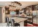 Modern kitchen featuring dark cabinetry, stainless steel appliances, granite countertops, and island seating at 7788 Ebro Valley Ct, Las Vegas, NV 89113