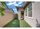 A backyard with artificial turf and a covered patio visible through an open doorway enhances the outdoor living experience at 789 Goodman Cove St, Henderson, NV 89011