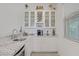 Stylish bar area with granite countertops, glass cabinets, and a sink at 789 Goodman Cove St, Henderson, NV 89011